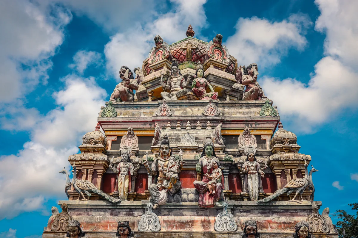 Gopuram sculpté d'un temple hindou du sud de l'Inde sous un ciel nuageux