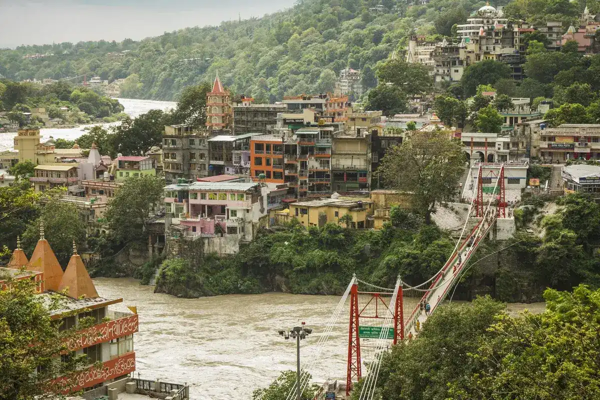 Pont suspendu au-dessus du Gange à Rishikesh, avec les ghats et les temples sur la rive