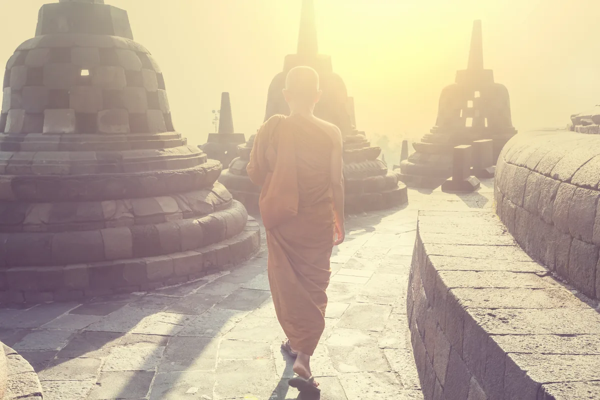 Deux moines marchant à l'aube sur les terrasses d'un temple bouddhiste en Asie du Sud-Est